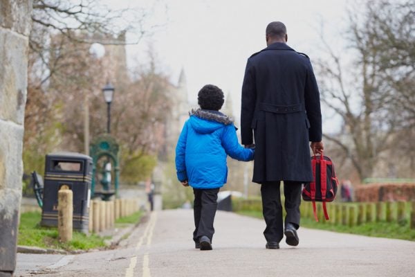 A father and his son walk to school