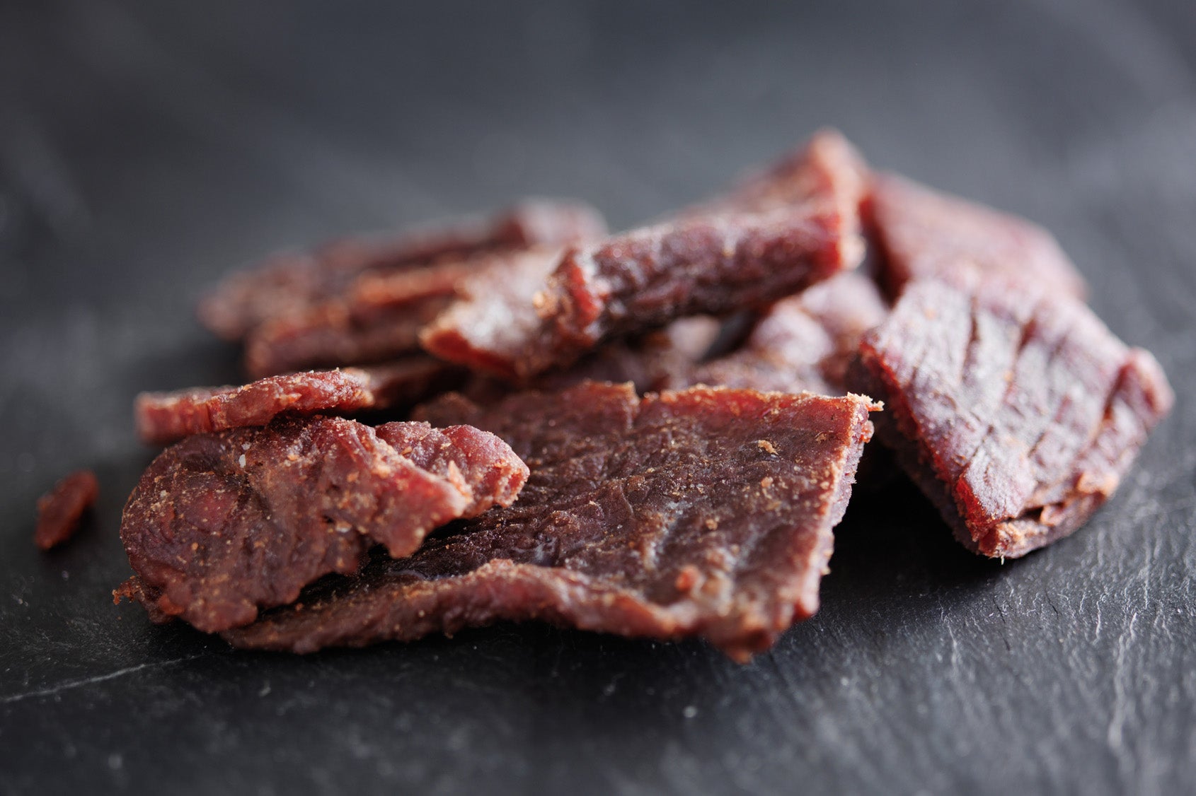 beef jerky in a pile on slate surface
