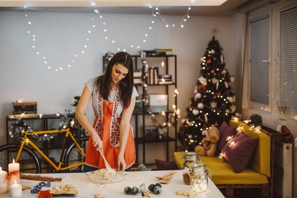 A woman in the kitchen in front of a Christmas tree