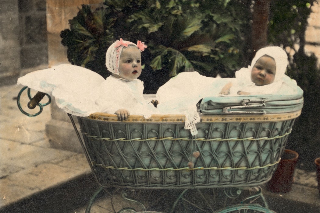 Vintage Portrait of two Babies in an Old Fashioned Antique Baby Carriage Buggy