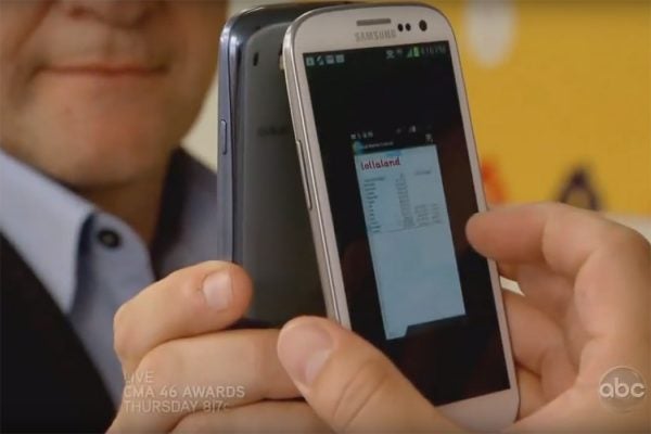 A man holding a cell phone against a mirror