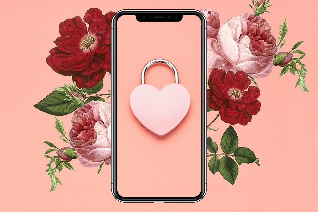A phone with a heart-shaped lock on its screen and roses in the background