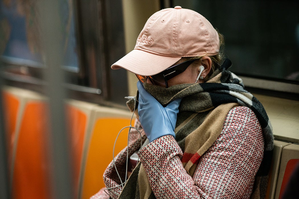 A woman wearing a protective mask sits in a subway car at Grand Central Terminal on March 12, 2020 in New York City.