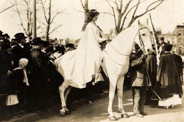 Lawyer Inez Milholland, wearing white cape, seated on white horse at the National American Woman Suffrage Association parade, March 3, 1913, Washington, D.C.