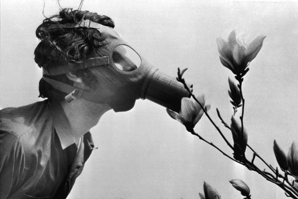 A Pace College student in a gas mask "smells" a magnolia blossom in City Hall Park on Earth Day, April 22, 1970, in New York.