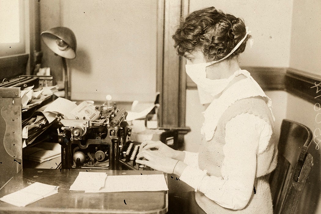 A typist wearing an influenza mask in 1918