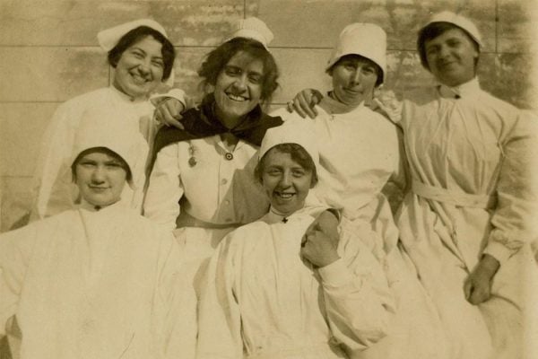 A graduate nurse and student nurses in isolation uniforms, early 1900s