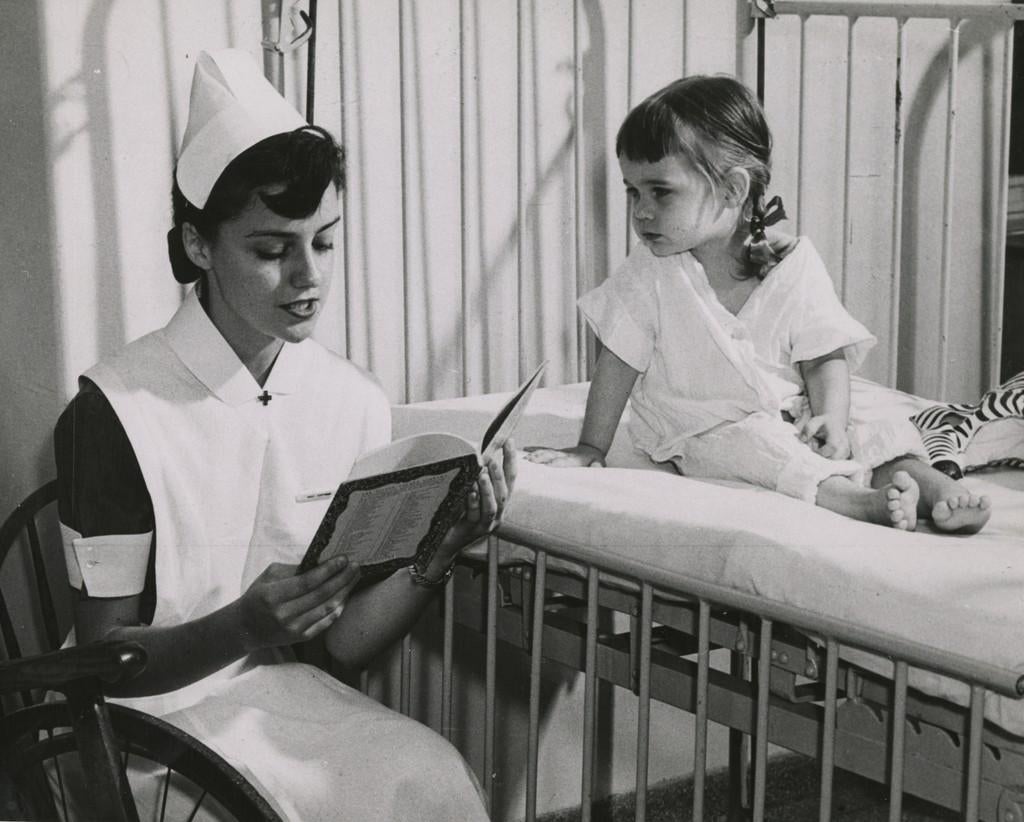 Student nurse Janie Hartman reading to a pediatric patient, early 1950s