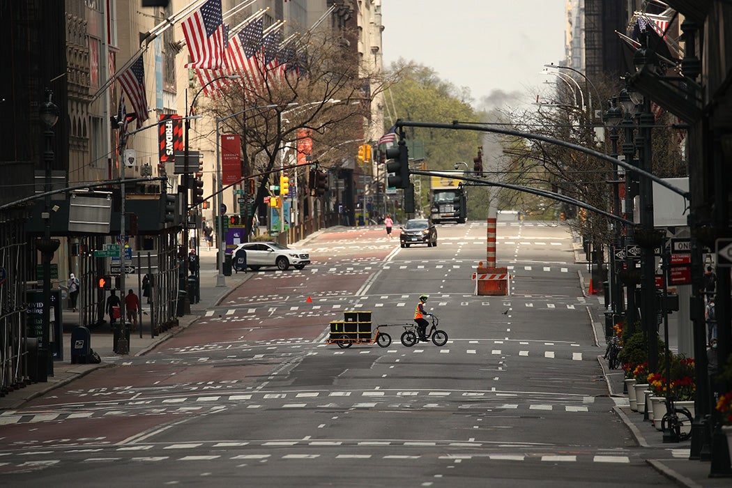 A delivery person is seen crossing a nearly empty 5th Avenue during the coronavirus pandemic on April 25, 2020 in New York City
