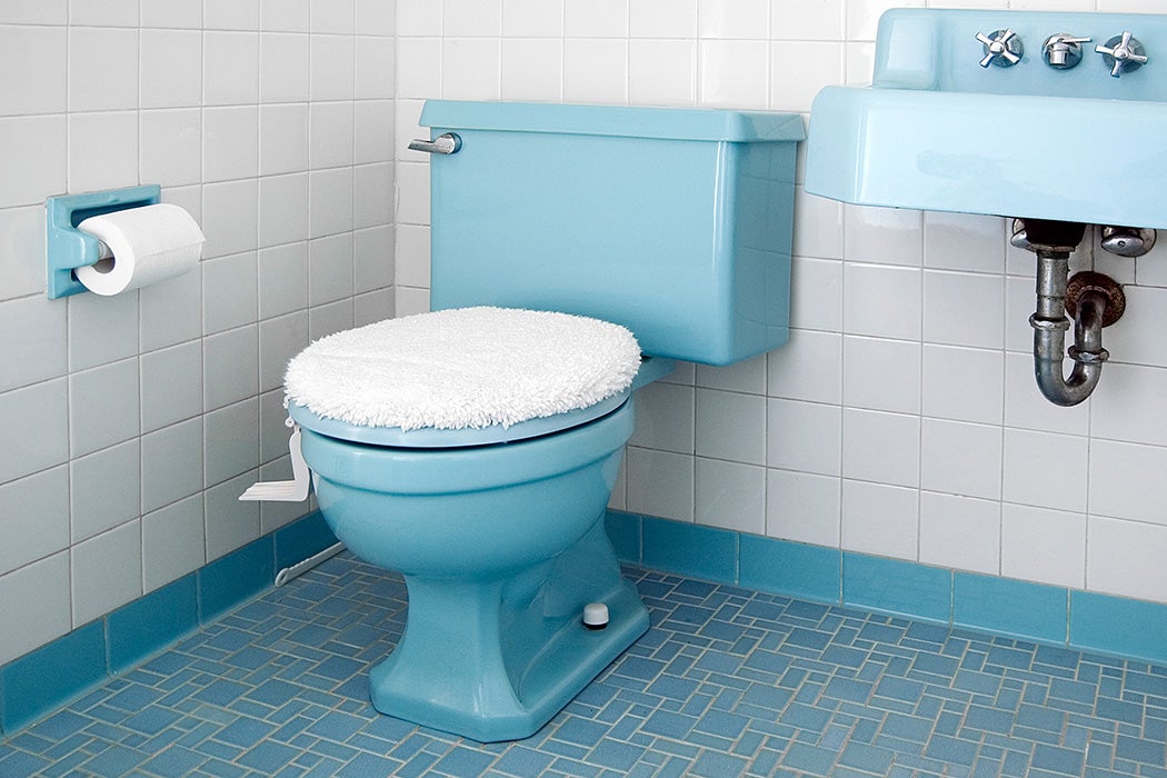 A blue toilet with its lid closed