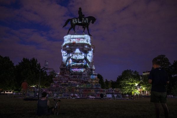 George Floyd's image is projected on the Robert E. Lee Monument as people gather around on June 18, 2020 in Richmond, Virginia.