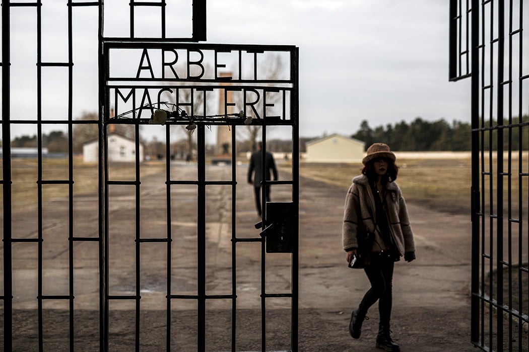 Посетители проходят мимо входных ворот в лагерь смерти Освенцим, самый печально известный из многих нацистских концлагерей. Getty