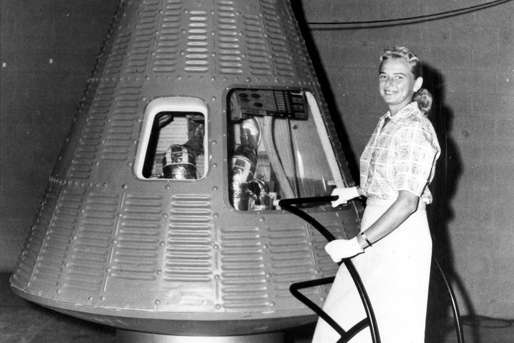 Jerrie Cobb poses next to a Mercury spaceship capsule.