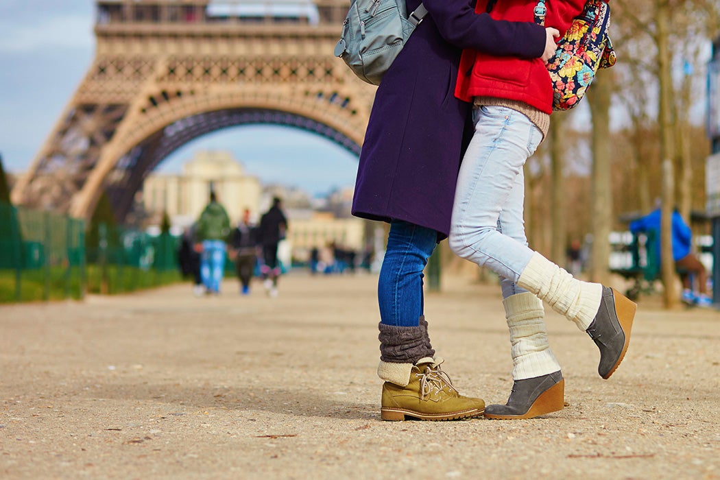 Two women hugging in front of the Eiffel Tower in Paris