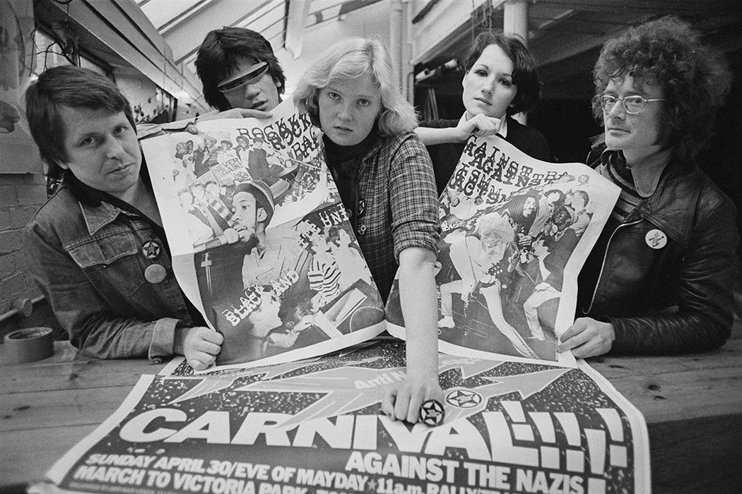English designer and typographer Roger Huddle with collaborators holding posters for 'Rock against Racism' and 'RAR/Anti Nazi League Carnival', London, UK, 27th April 1978