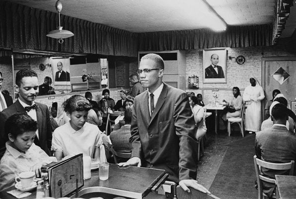 Malcolm X at Temple 7, a Halal restaurant on Lenox Avenue and 116th Street, Harlem, 1963