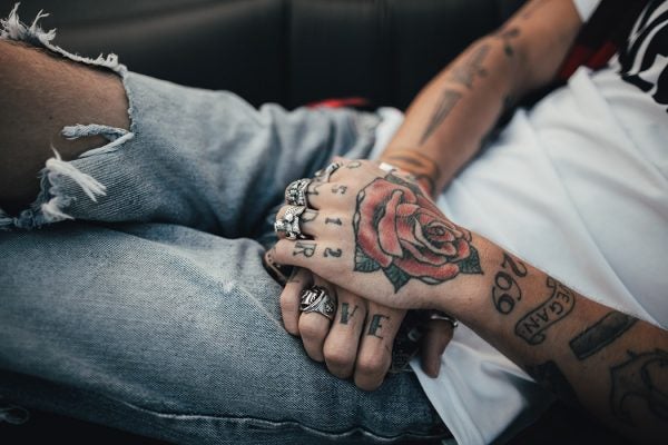 Two arms with tattoos