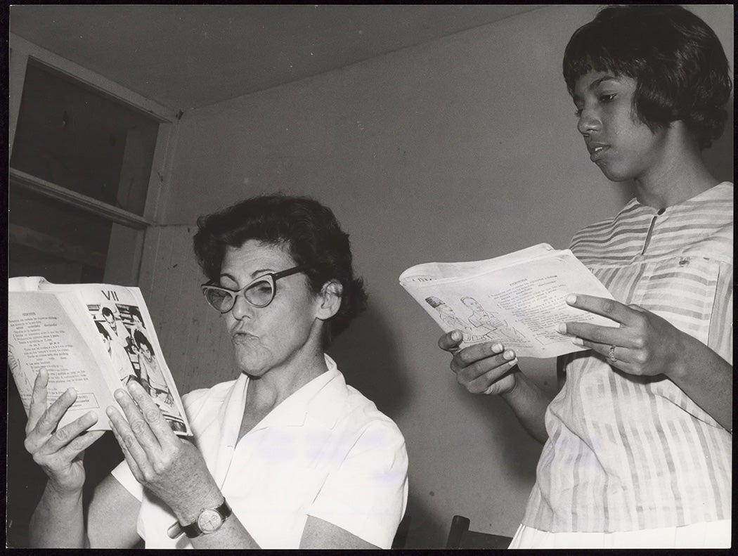 Two women read together at a literacy center near Havana