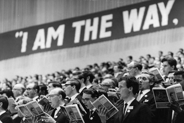 Photograph: A choir at the  Billy Graham evangelist crusade at London's Earls Court sing to 20,000 crowd under the  slogan ' I am the way'.  

Source: Photo by Fox Photos/Getty Images