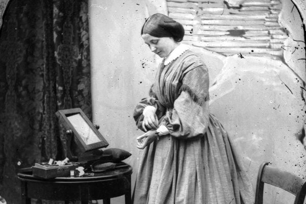: A woman adjusting her dress, London, c. 1865