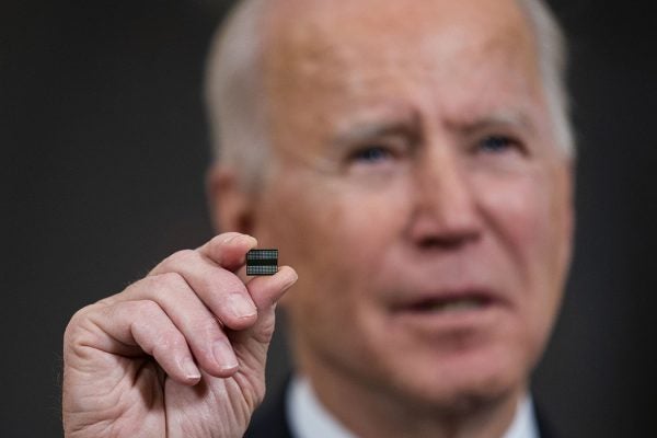 President Joe Biden holds a semiconductor during his remarks before signing an Executive Order on the economy