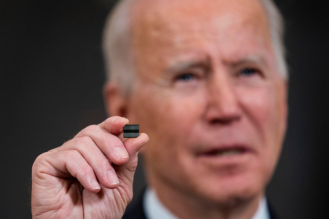 President Joe Biden holds a semiconductor during his remarks before signing an Executive Order on the economy