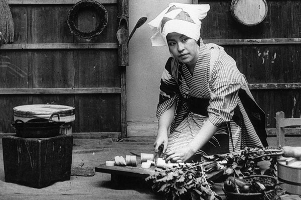 A Japanese woman cuts up radishes in her kitchen