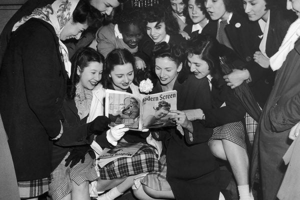 Photograph: Female fans of Frank Sinatra gaze adoringly at a picture of him in a copy of Modern Screen magazine, c. 1950

Source: Getty