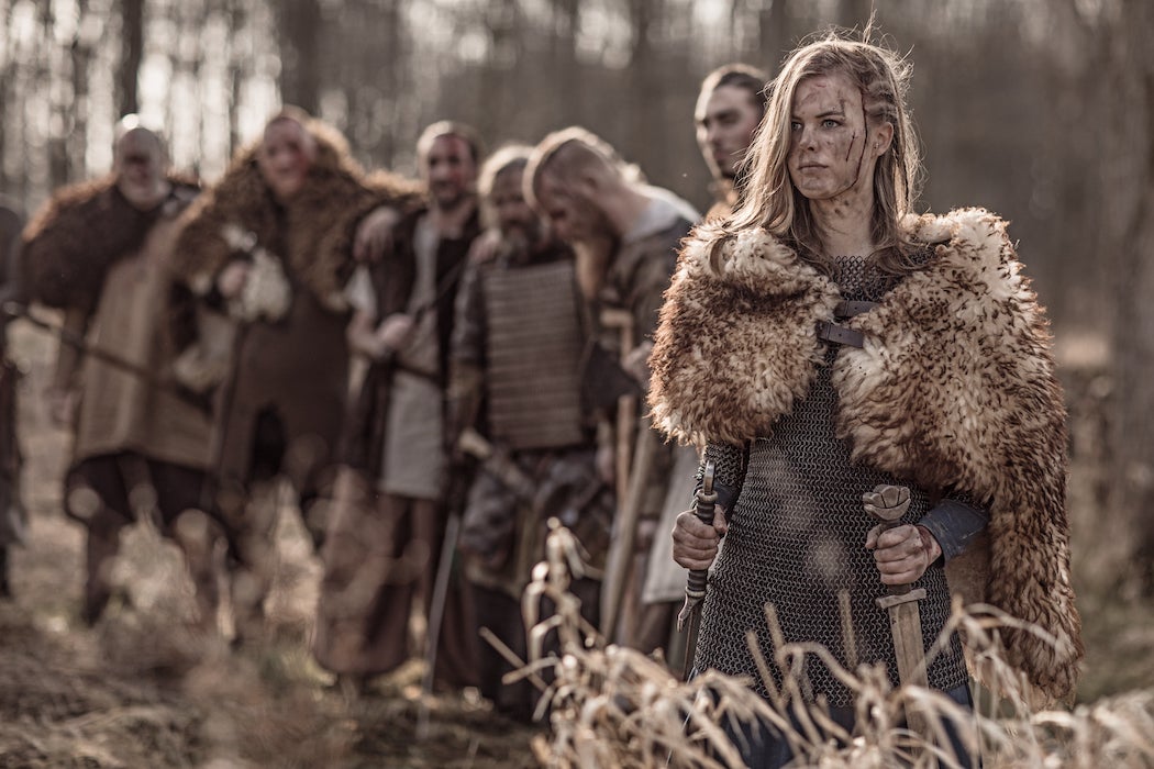 Female viking warrior looks on with her army