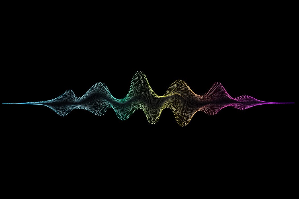 An abstract spectrum of colored dots on a black background that cohere together to represent sound waves or a music equalizer.