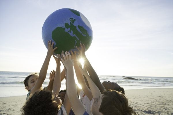 A group of children holding up a small globe