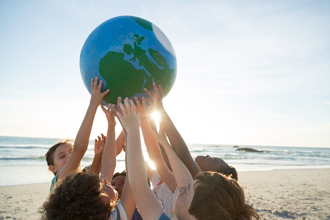 A group of children holding up a small globe