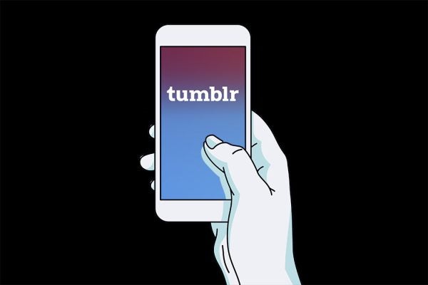 A hand holding a smartphone with a tumblr logo