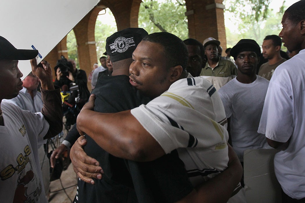 Jim Allen (L), a self-described member of the Vice Lords street gang, gets a hug from former Gangster Disciple and current community activist Q. L. Anthony following a press conference September 2, 2010 in Chicago, Illinois.
