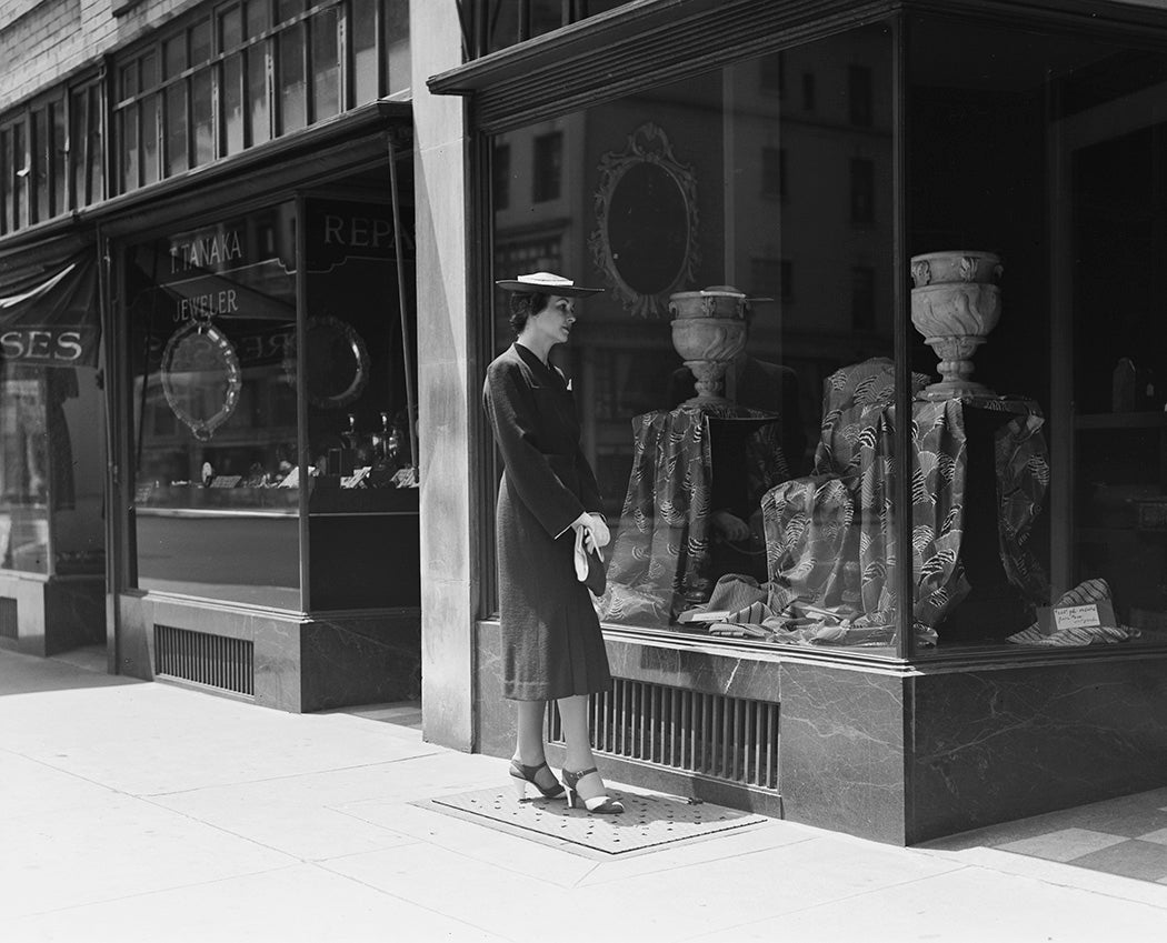 Model Carol Carter looks at two stone urns in the window of a shop on Madison Avenue and 63rd Street in New York City, June 1938. 