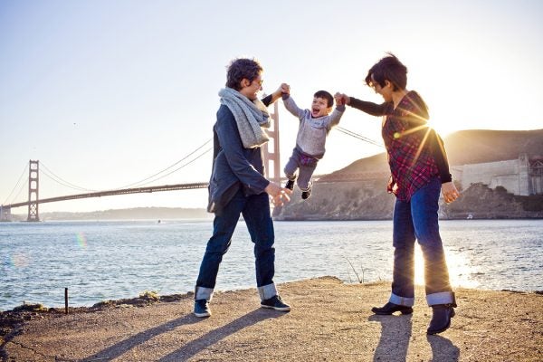 Two moms playing with son in front of Golden Gate Bridge, San Francisco
