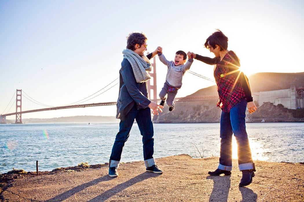 Two moms playing with son in front of Golden Gate Bridge, San Francisco