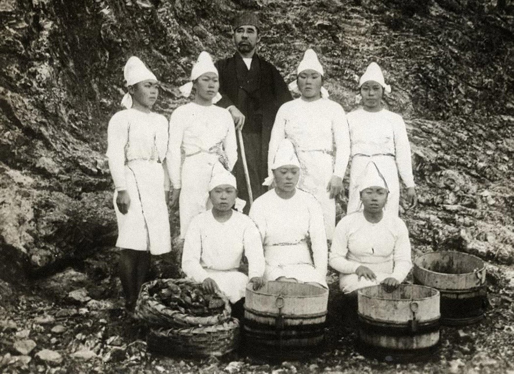 Female pearl divers next to Kokichi Mikimoto, inventor of cultivating pearls. Japan, 1921.