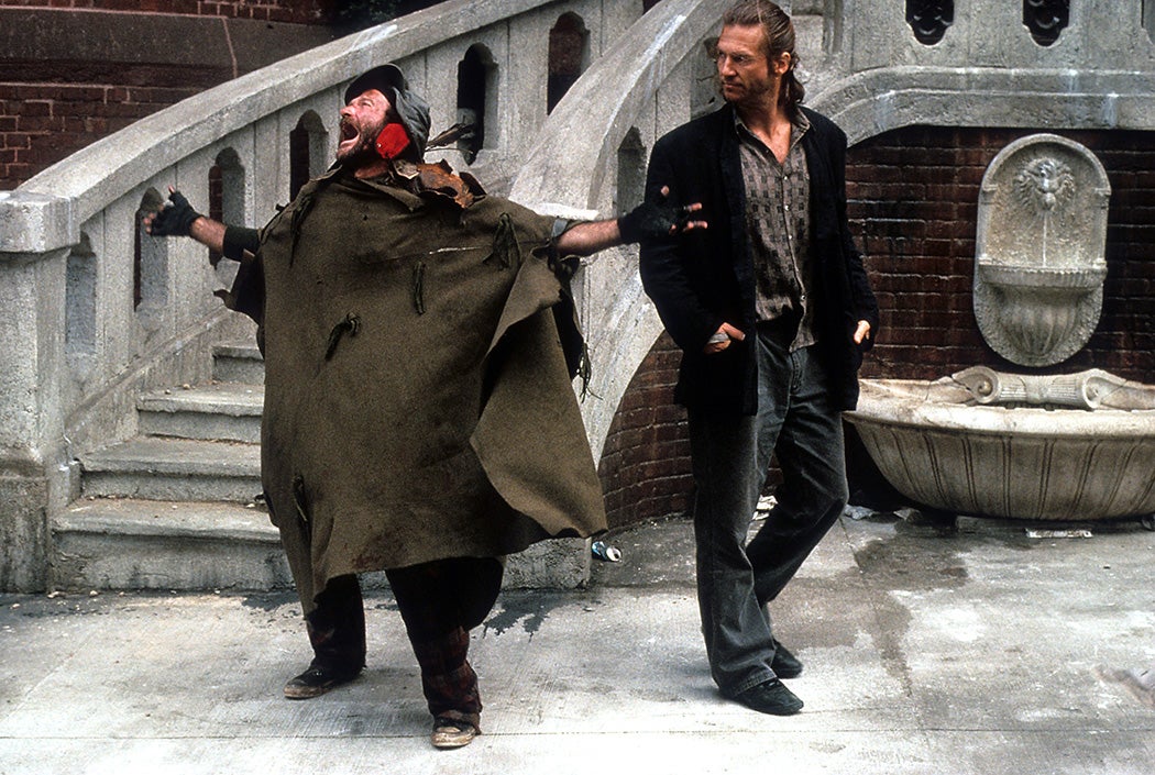 Robin Williams shouting in the street as Jeff Bridges watches in a scene from the film 'The Fisher King', 1991.