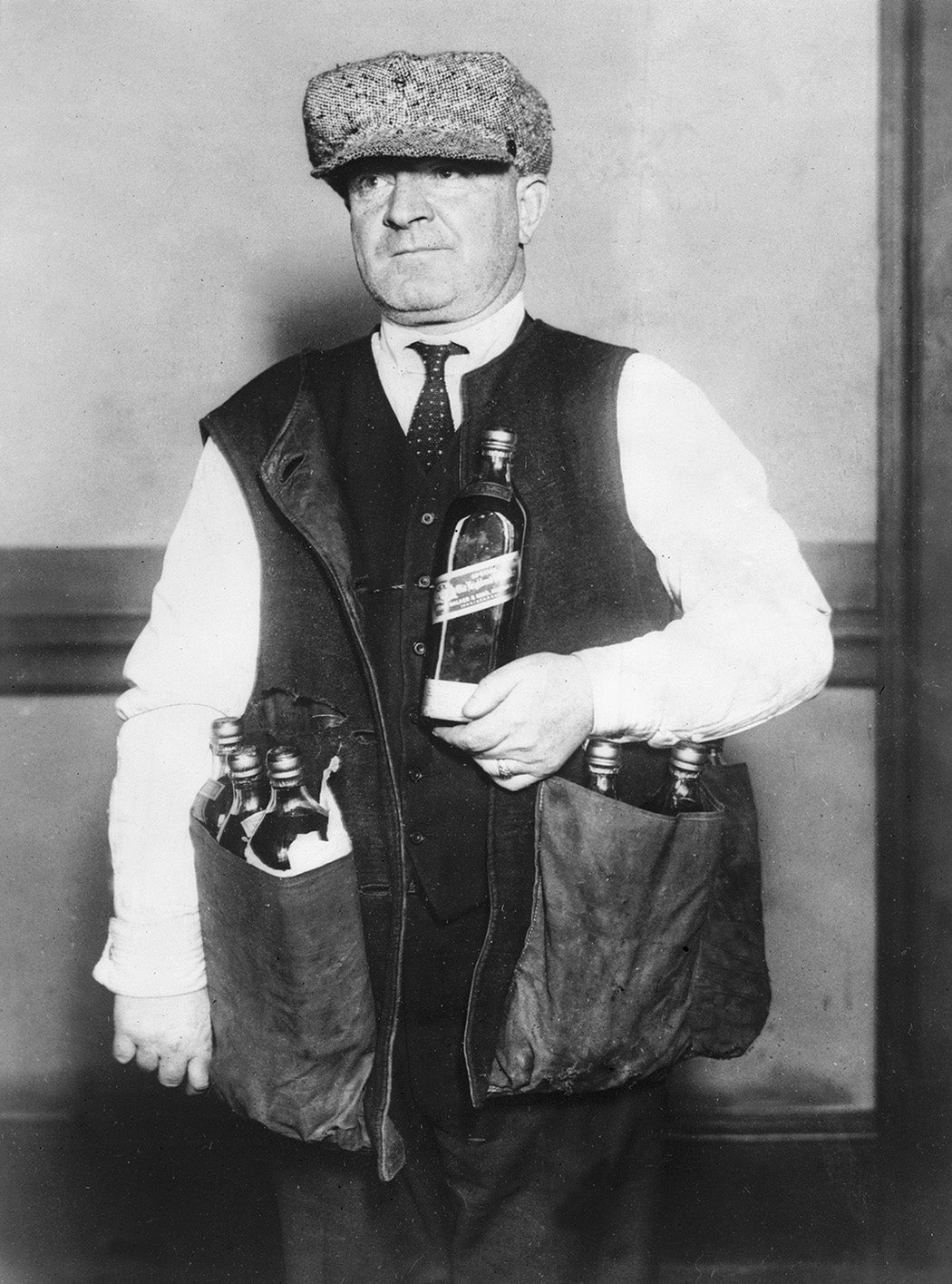 A revenue agent wearing a waistcoat designed to hide whisky during the prohibition era in America, 1923