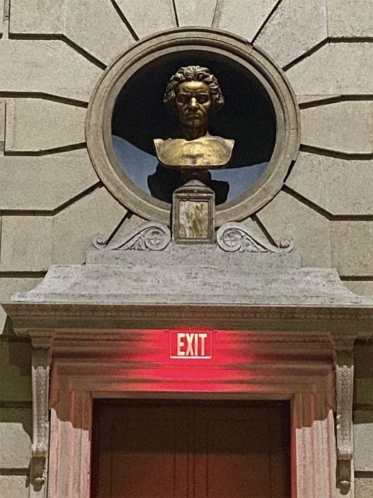 Beethoven glaring at students from above an exit sign (“you should be practicing!”). One of the several busts of canonical figures distributed throughout Eastman’s campus