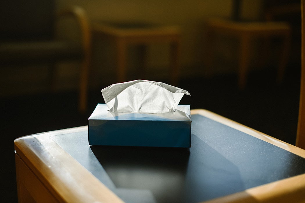 Cardboard box of paper tissues on a wooden table.
