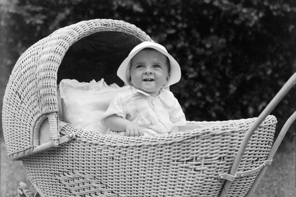 Portrait of a baby in a light coloured stroller