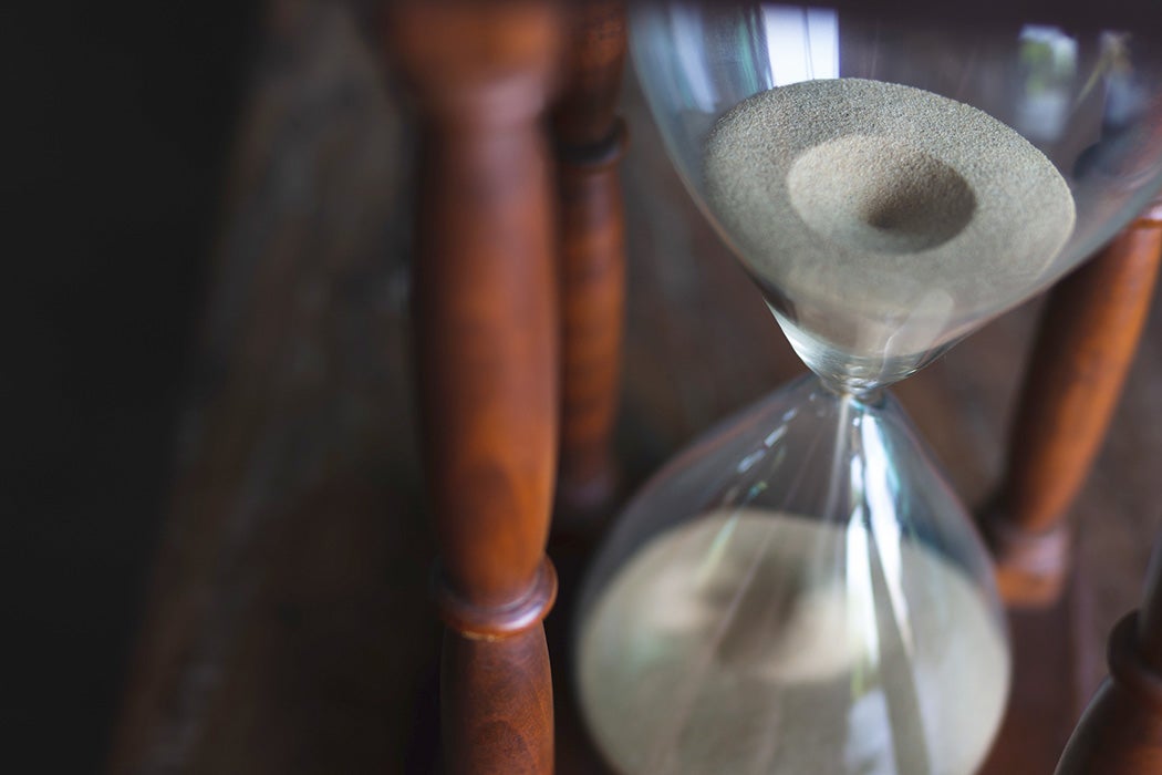 Close-up Vintage Wooden Hourglass on Wooden Background, Sand running through the bulbs for measuring the passing time