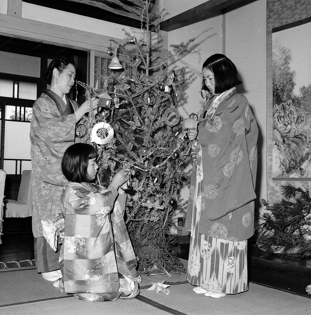Japanese Christians, wearing traditional kimonos, decorate their christmas tree in a Yokahama home, c. 1950