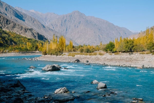 Turquoise Blue River Flowing Along Hindu Kush Mountain Range In Ghizer Valley, Gb, Pakistan.