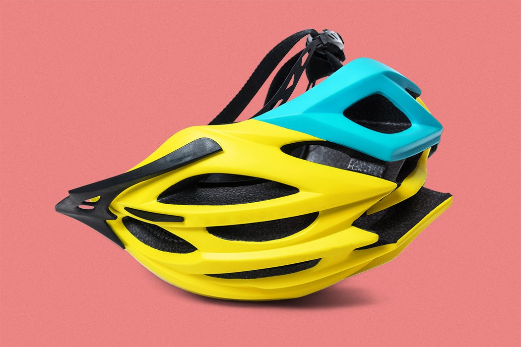 Yellow bicycle helmet upside-down isolated on red background