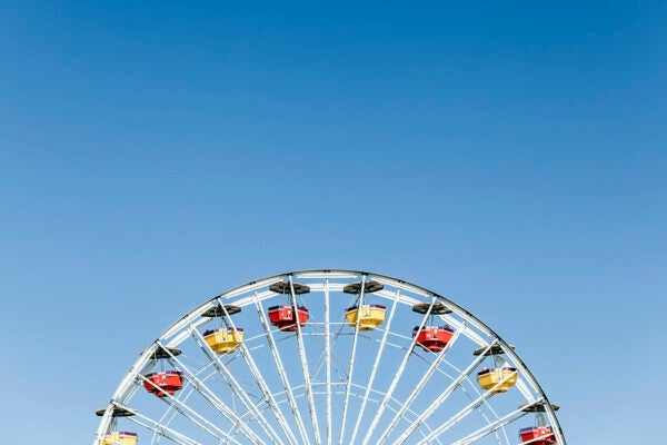Low angle view of Ferris wheel against clear blue sky