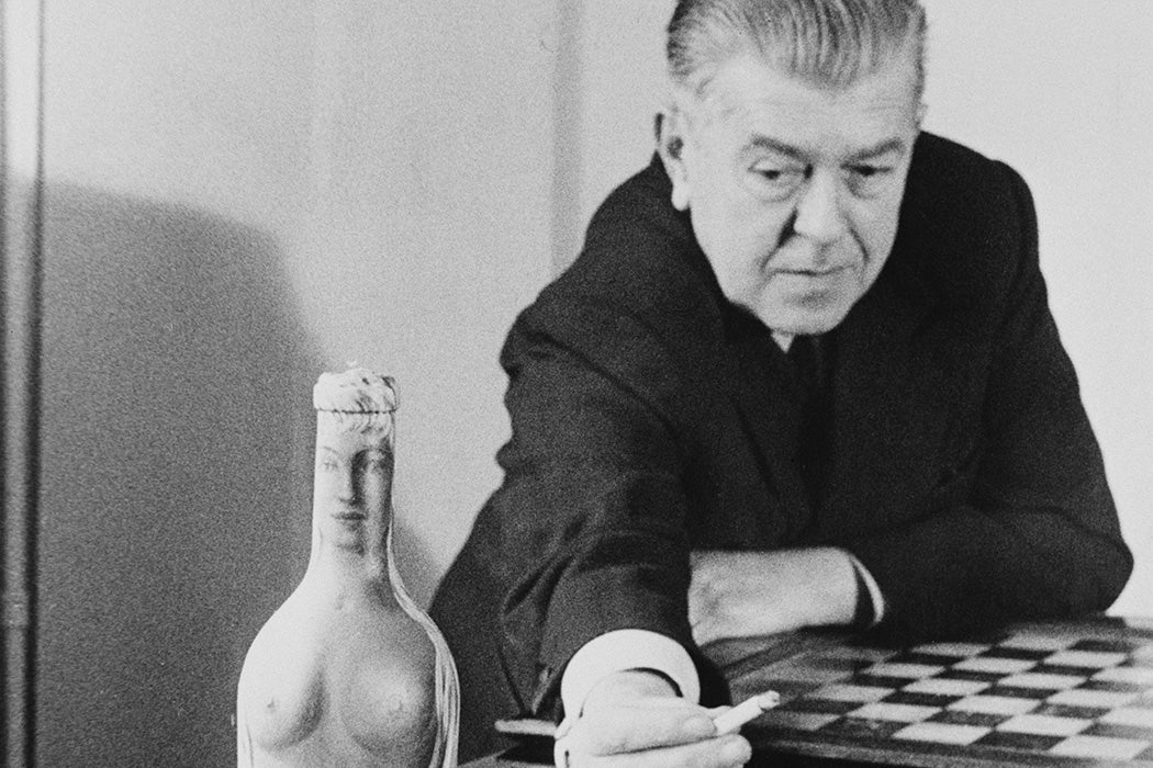 Rene Magritte with 'Femme-Bouteille', his oil painting of a nude on a glass bottle, circa 1955