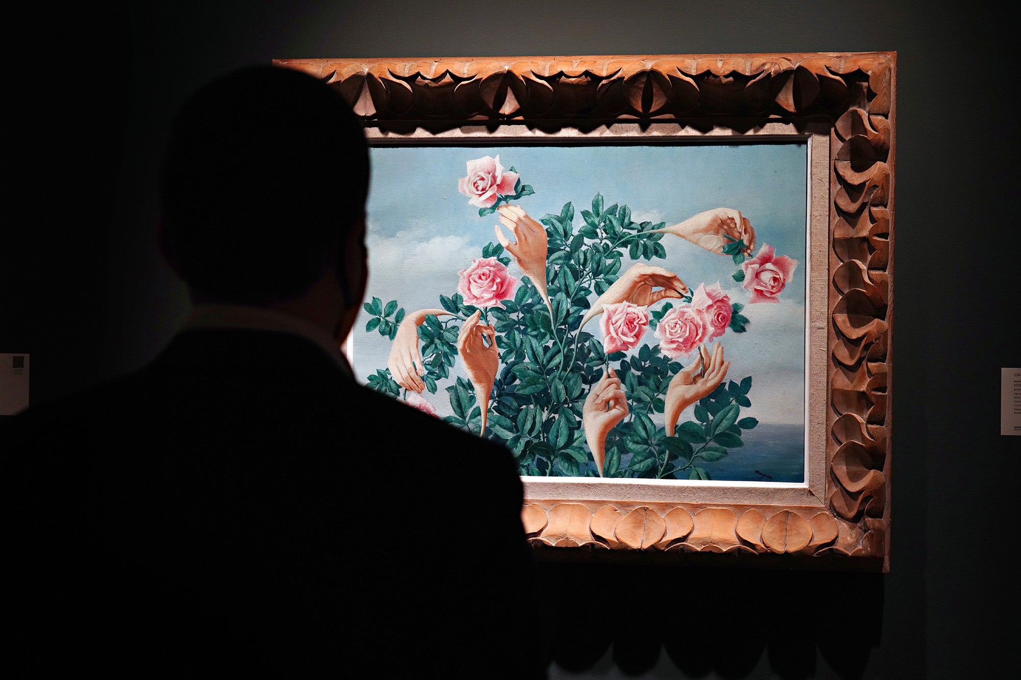 A person wearing a protective mask looks at "Rêverie de Monsieur James" by René Magritte during a press preview of the upcoming Impressionist and Modern Art Evening Sale at Sotheby's on October 23, 2020 in New York City. (Photo by Cindy Ord/Getty Images)